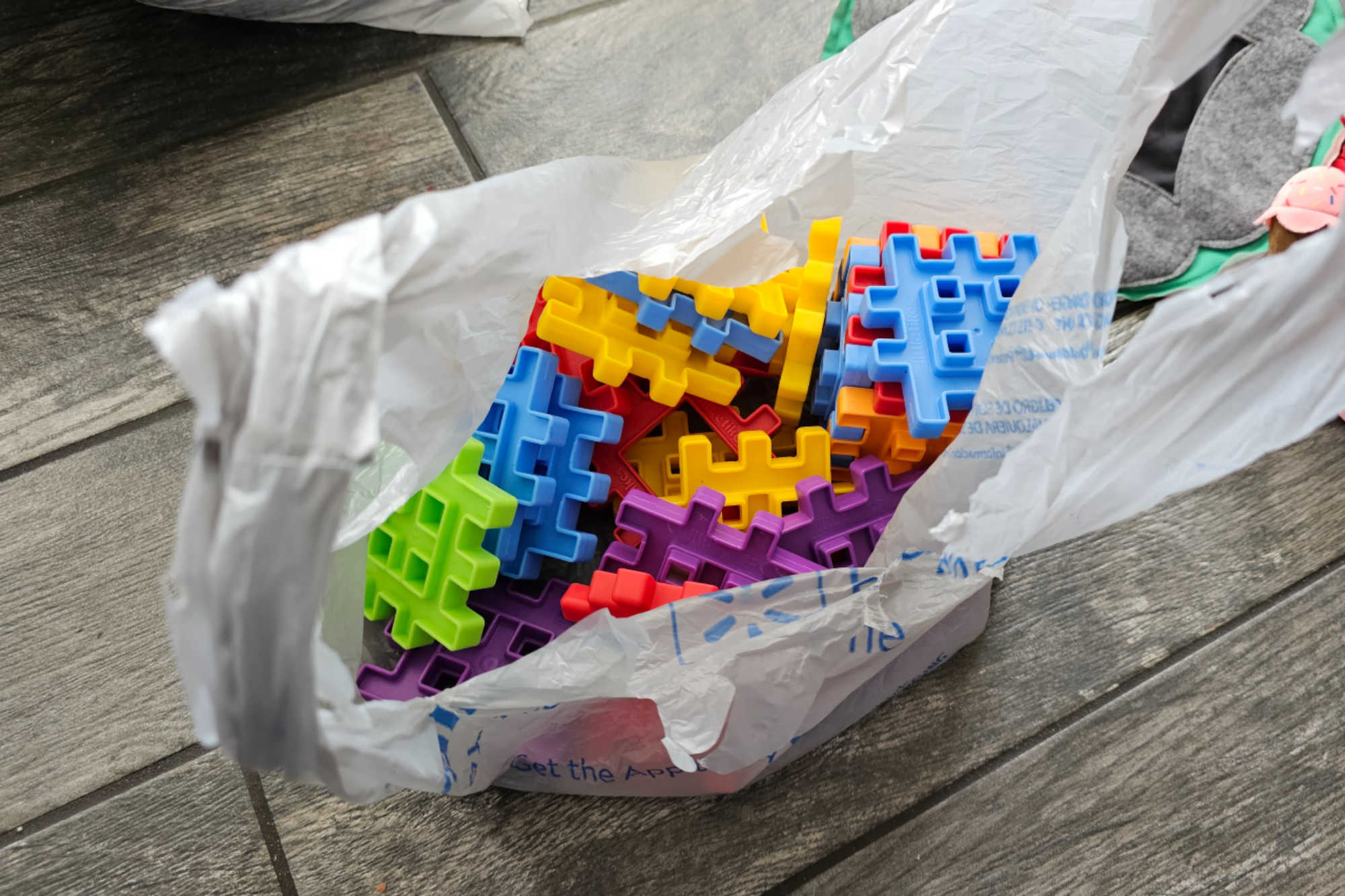A set of colorful waffle-shaped blocks—part of a set—in a small grocery bag. These blocks are being bagged separately to keep the set together.
